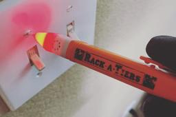 the rack-a-tiers ultimate ac sensor non contact voltage tester being used on a light switch screw.